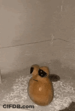 A Potato Is Sitting In A Bathtub With Water Coming Out Of The Drain . GIF