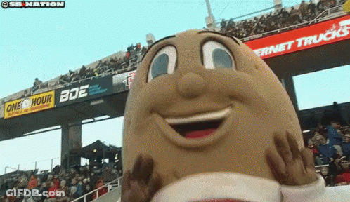 A Potato Mascot Is Smiling In Front Of A Crowd Of People GIF