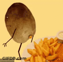 A Potato With Arms And Legs Is Standing Next To A Plate Of French Fries .. GIF