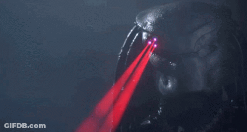 A Predator 'S Eyes Are Glowing Red In The Dark GIF