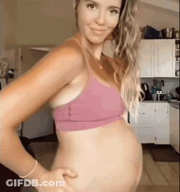 Pregnant Woman In Pink Bra Holding Belly GIF