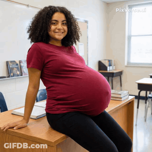 A Pregnant Woman Sits On A Desk In A Classroom With Pixverse.ai Written In The Corner GIF