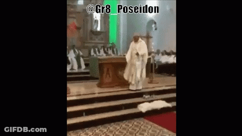 A Priest In A White Robe Is Standing On A Stage In A Church GIF