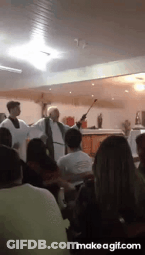 A Priest Is Giving A Sermon In Front Of A Crowd Of People GIF