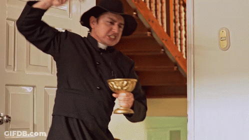 A Priest Is Holding A Golden Chalice In His Hand GIF
