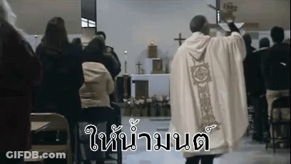 A Priest Is Standing In Front Of A Crowd Of People In A Church Giving A Sermon . GIF