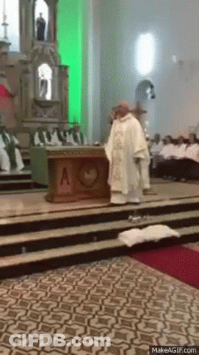 A Priest Is Standing In Front Of An Altar With A Heart On It GIF