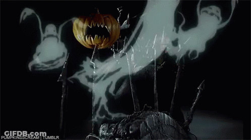 A Pumpkin With A Bat On It 'S Face Is Surrounded By Ghosts In A Dark Room . GIF