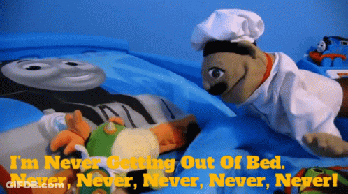 A Puppet Is Laying On A Bed With The Words " I 'M Never Getting Out Of Bed Never Never Never Never " GIF