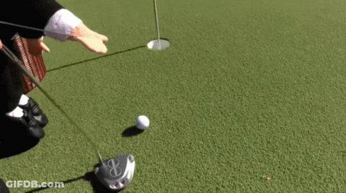 A Puppet Is Playing Golf On A Green Near A Body Of Water GIF