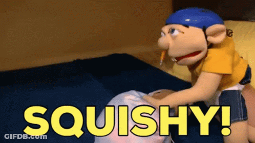 A Puppet Is Sitting On A Bed With The Words Squishy Written In Yellow GIF