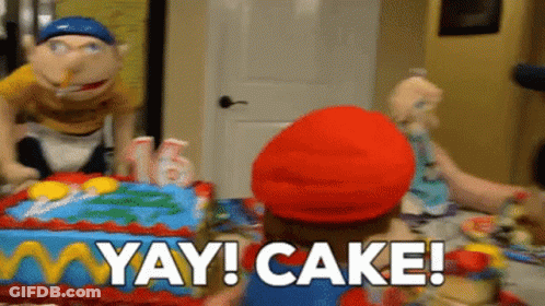 A Puppet Is Standing In Front Of A Birthday Cake With The Words Yay Cake Written On It . GIF