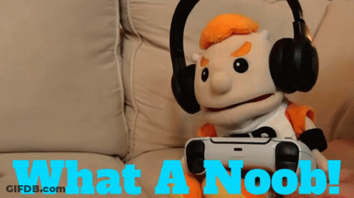 A Puppet Is Wearing Headphones And Holding A Video Game Controller With The Words What A Noob Below Him GIF