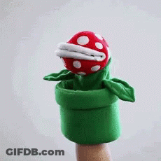 A Puppet Of A Carnivorous Plant Is Being Held By A Hand GIF