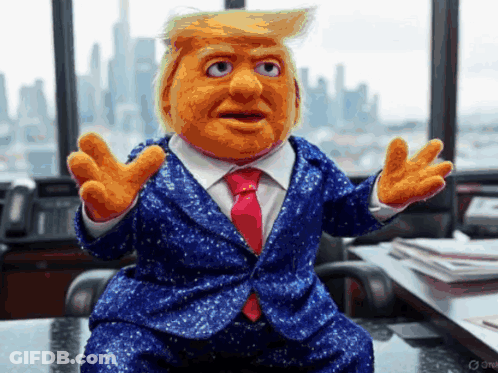 A Puppet Of Donald Trump Is Sitting At A Desk GIF