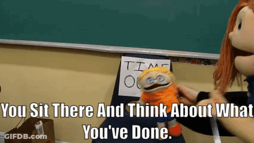 A Puppet Sits In Front Of A Sign That Says " Time Out " GIF