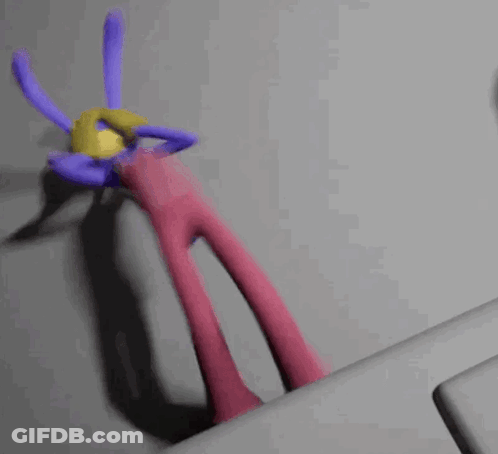A Purple And Pink Cartoon Character With A Yellow Ball On Its Head GIF