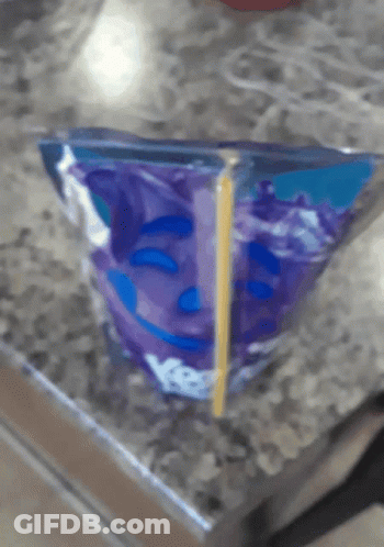 A Purple Bag With A Smiley Face On It Sits On A Table GIF