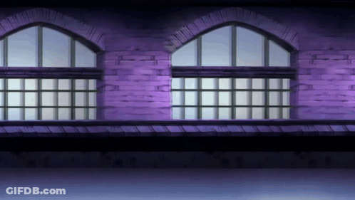 A Purple Brick Building With Arched Windows And A Balcony GIF
