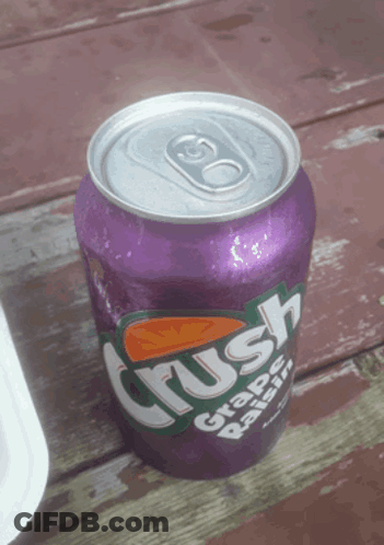 A Purple Can Of Crush Grape Raisin Soda On A Wooden Table GIF