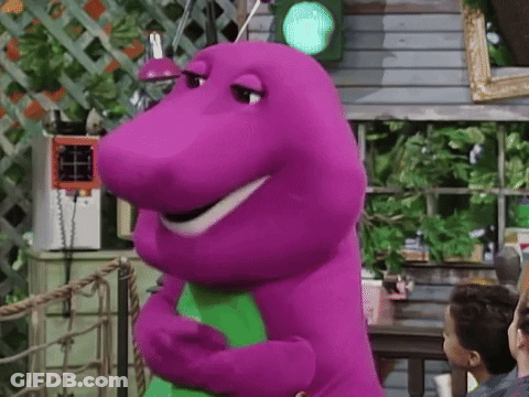 A Purple Dinosaur Is Standing In Front Of A Green Light And Smiling . GIF