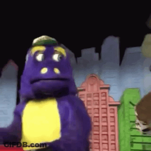 A Purple Dinosaur With A Yellow Chest Is Standing In Front Of A Cityscape . GIF