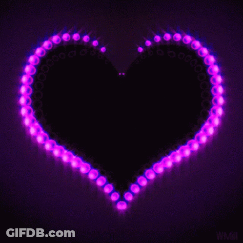 A Purple Heart Is Surrounded By Purple Lights On A Dark Background GIF