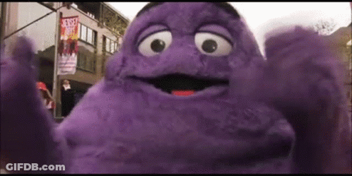 A Purple Mcdonald 'S Character Is Standing In Front Of A Street Sign That Says Street Art GIF