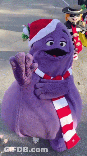 A Purple Mcdonald 'S Mascot Wearing A Santa Hat GIF