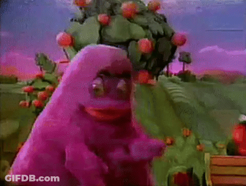 A Purple Monster Is Standing In Front Of A Cactus Tree . GIF