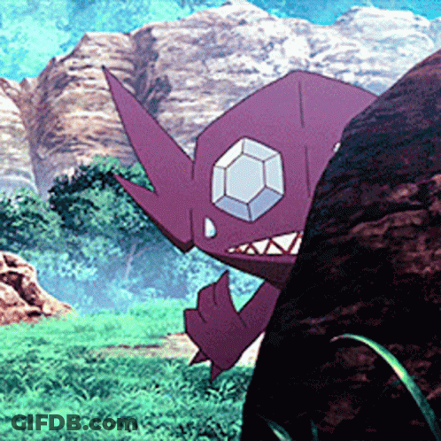A Purple Monster With A Diamond In Its Eye Is Standing Next To A Large Rock . GIF