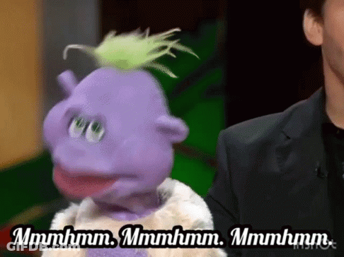 A Purple Puppet Is Standing Next To A Man In A Suit And Says Mmmmhm GIF