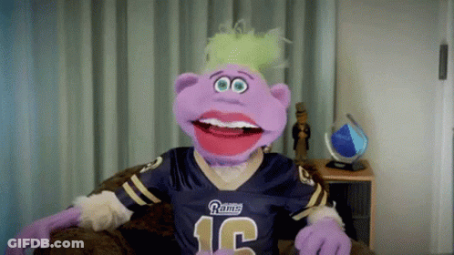 A Purple Puppet Wearing A Rams Jersey With The Number 12 On It GIF