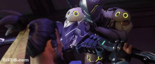 A Purple Robot With Yellow Eyes Is Being Held By Two People GIF