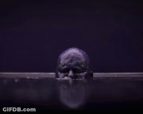 A Purple Skull Is Floating In A Dark Room In The Water . GIF