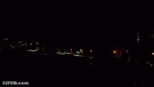 A Purple Sky With A Few Clouds And A Tower In The Distance GIF