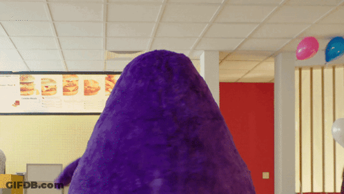A Purple Stuffed Animal In Front Of A Menu GIF