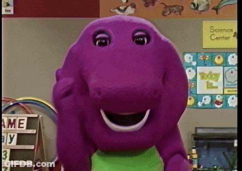 A Purple Stuffed Animal Is Smiling In Front Of A Science Center Sign GIF