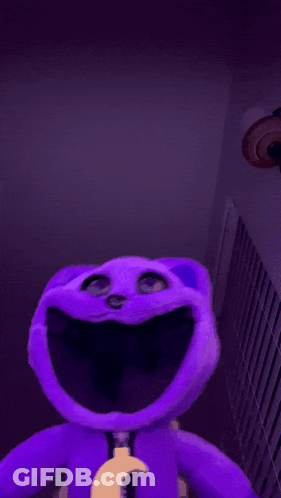 A Purple Stuffed Animal With Its Tongue Sticking Out GIF