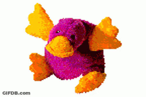 A Purple Stuffed Animal With Yellow Wings Is Sitting On A White Background GIF