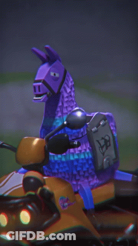 A Purple Toy Llama Is Riding On The Back Of An Orange Vehicle GIF