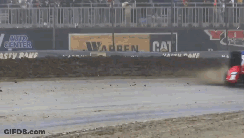 A Race Car Is Driving Down A Track With A Cat Advertisement In The Background GIF