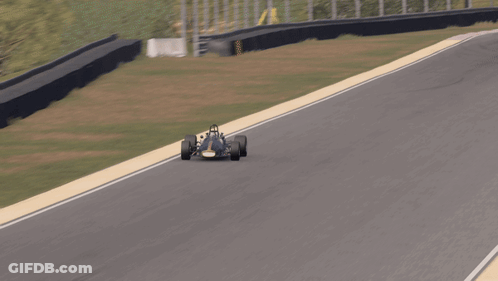 A Race Car Is Driving Down A Track With A Red And White Stripe GIF