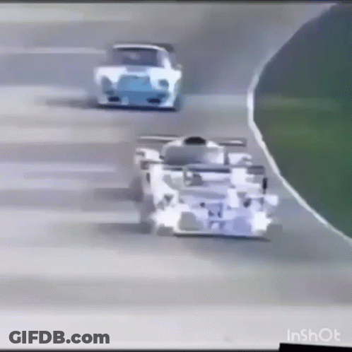 A Race Car Is Driving Down A Track With Other Cars Behind It . GIF
