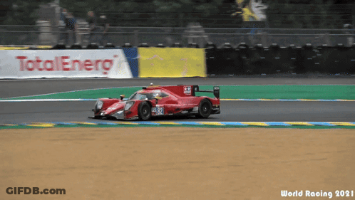 A Race Car Is Driving On A Track With A Total Energy Banner Behind It GIF