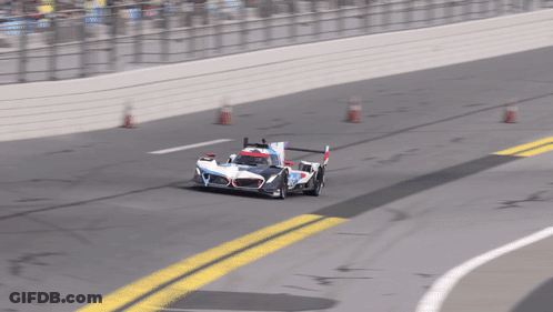 A Race Car Is Going Around A Curve On A Race Track GIF