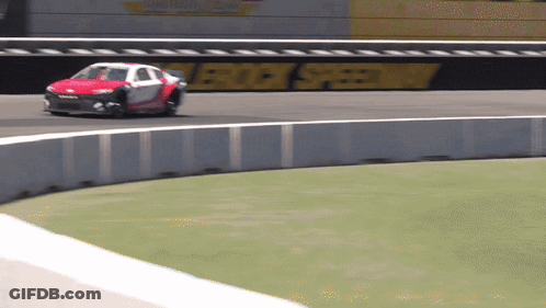 A Race Car Is Going Around A Curve On A Track With A Sign That Says Rock Speedway In The Background GIF
