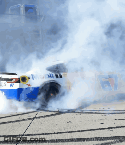 A Race Car With The Number 67 On It Is Smoking GIF
