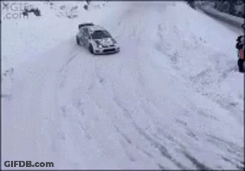 A Rally Car Is Driving Through The Snow On A Track . GIF
