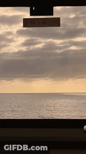 A Rear View Mirror Shows A View Of The Ocean GIF
